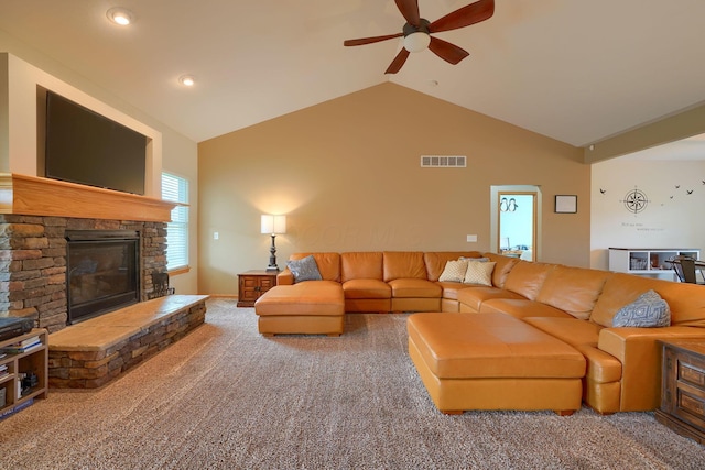 living room featuring ceiling fan, a stone fireplace, carpet floors, and vaulted ceiling