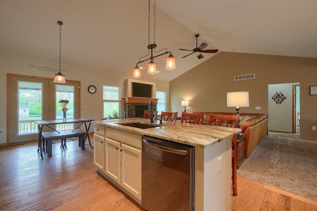 kitchen with visible vents, open floor plan, dishwasher, and a sink