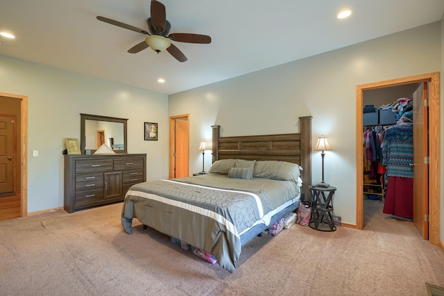 bedroom with recessed lighting, light colored carpet, and a spacious closet