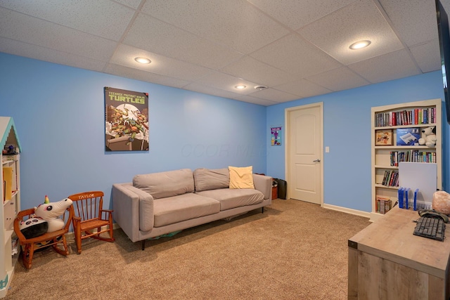 carpeted living room featuring a paneled ceiling and baseboards