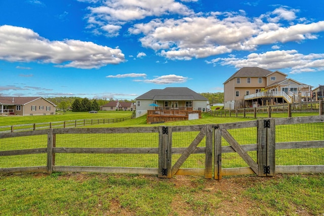 view of gate with fence private yard and a lawn
