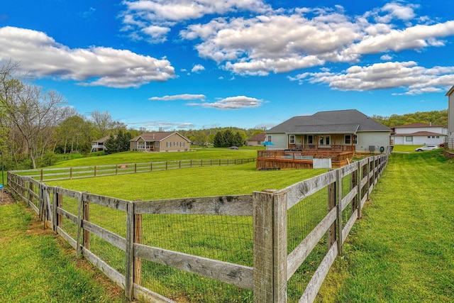 view of yard featuring a deck, a rural view, and a fenced backyard