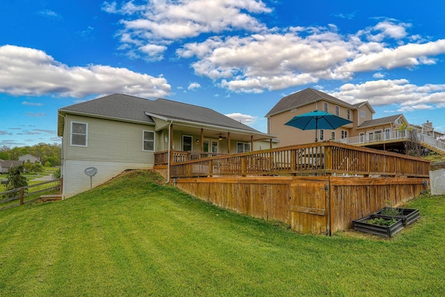 back of house featuring ceiling fan, fence, a wooden deck, and a lawn