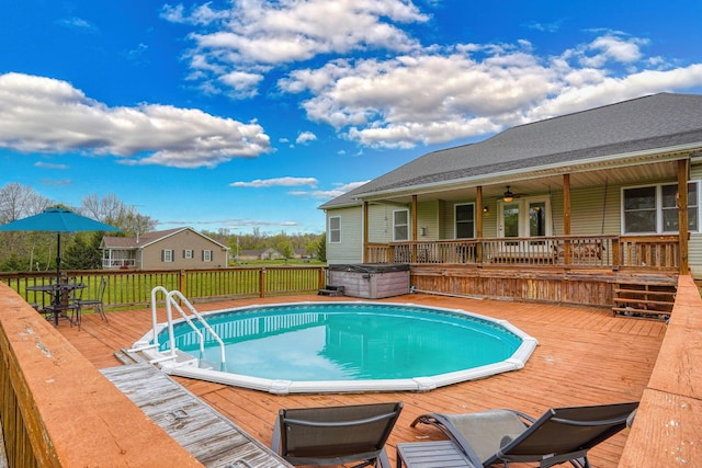 view of swimming pool featuring a fenced in pool, a deck, ceiling fan, and a hot tub