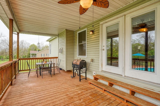 deck with area for grilling, a ceiling fan, and outdoor dining space