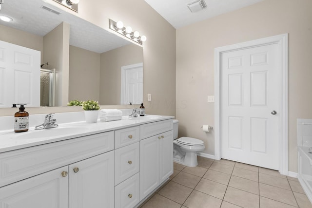 bathroom with toilet, tile patterned floors, visible vents, and a sink