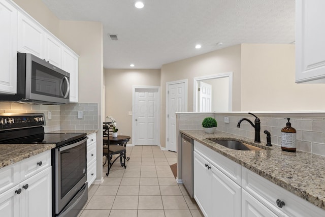 kitchen with a sink, tasteful backsplash, stainless steel appliances, and white cabinets