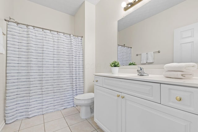 bathroom featuring tile patterned flooring, toilet, and vanity