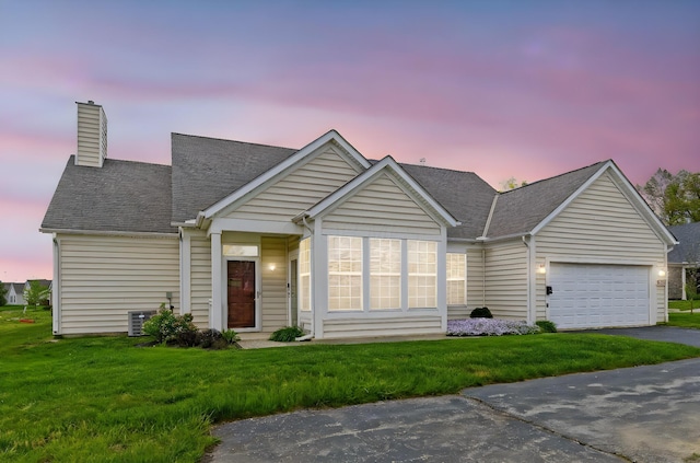 ranch-style house featuring a garage, a front yard, a chimney, a shingled roof, and driveway