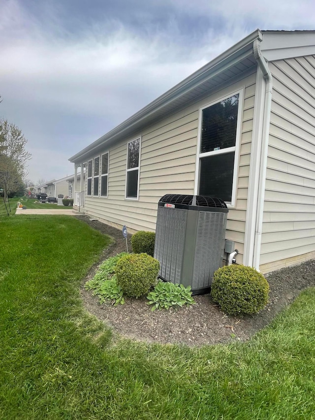 view of side of property featuring a lawn and central AC unit