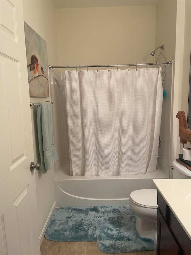 full bath featuring tile patterned flooring, shower / bath combo, vanity, toilet, and baseboards