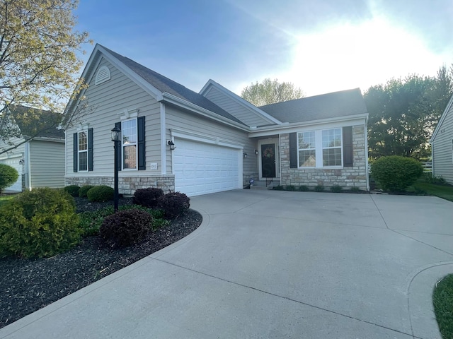 view of front of property with a garage, stone siding, and concrete driveway