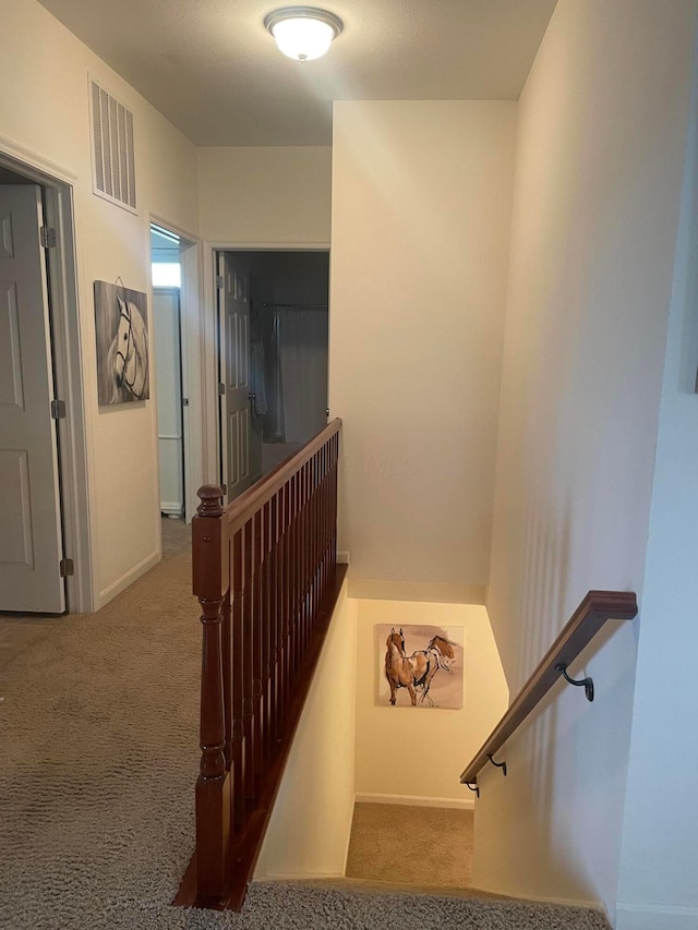 stairway with baseboards, carpet flooring, and visible vents