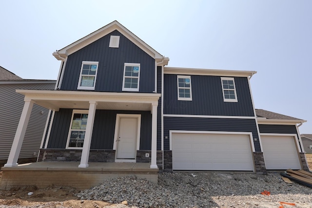 1544 Slippery Rail Dr, Plain City, OH 43064 - view of front of home featuring a porch, board and batten siding, stone siding, driveway, and a garage