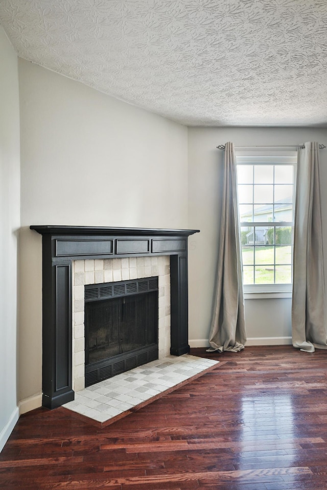 38 Ravine Ridge Dr S, Powell, OH 43065 - details featuring baseboards, a tiled fireplace, wood finished floors, and a textured ceiling