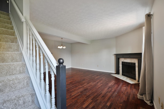 38 Ravine Ridge Dr S, Powell, OH 43065 - stairway featuring wood finished floors, a textured ceiling, a fireplace, baseboards, and a notable chandelier