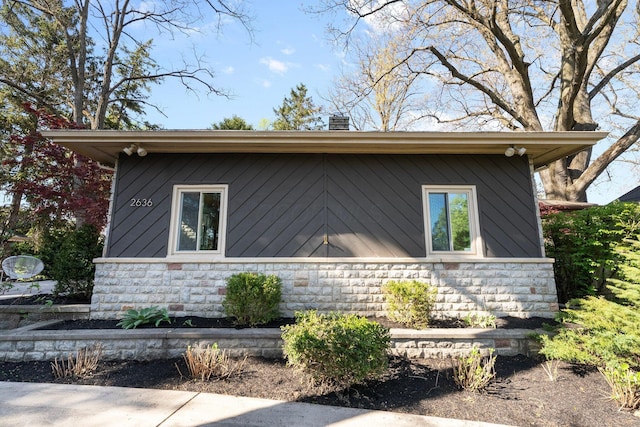 view of home's exterior with stone siding and a chimney