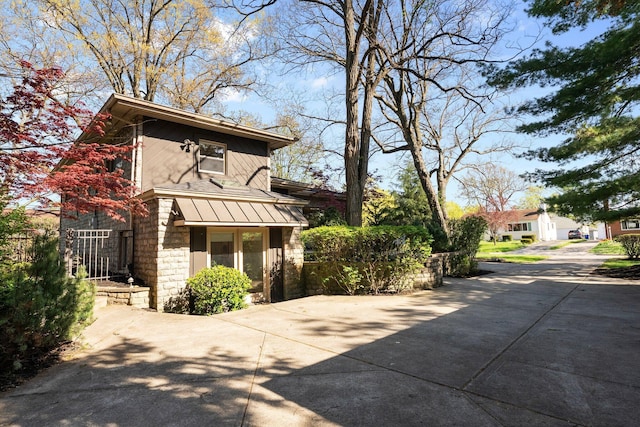 exterior space featuring driveway and stone siding