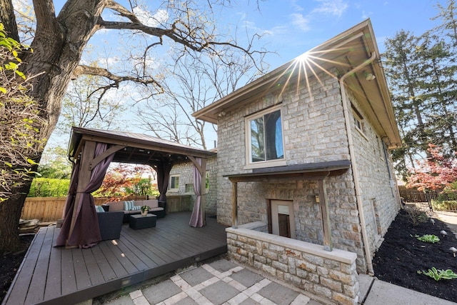 deck with a gazebo, fence, and an outdoor hangout area