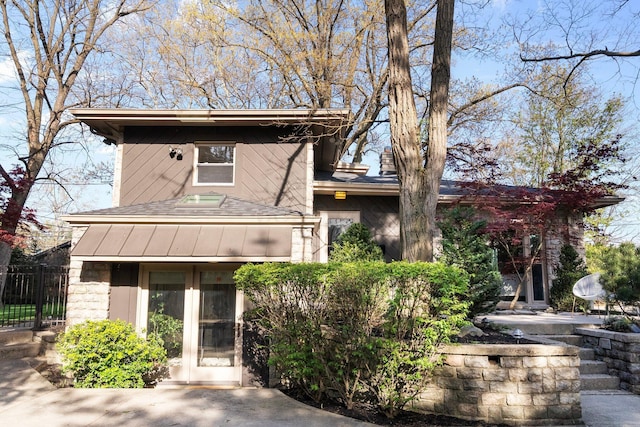 view of front of property featuring fence, a patio area, and a shingled roof
