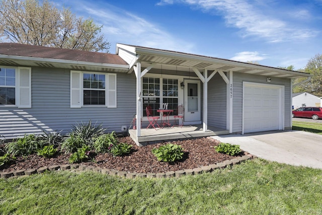ranch-style home featuring a porch, an attached garage, and concrete driveway