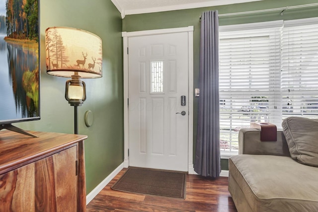 foyer with baseboards, crown molding, and wood finished floors