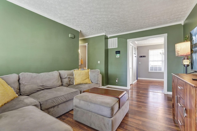 living area featuring baseboards, dark wood-style flooring, a textured ceiling, and visible vents