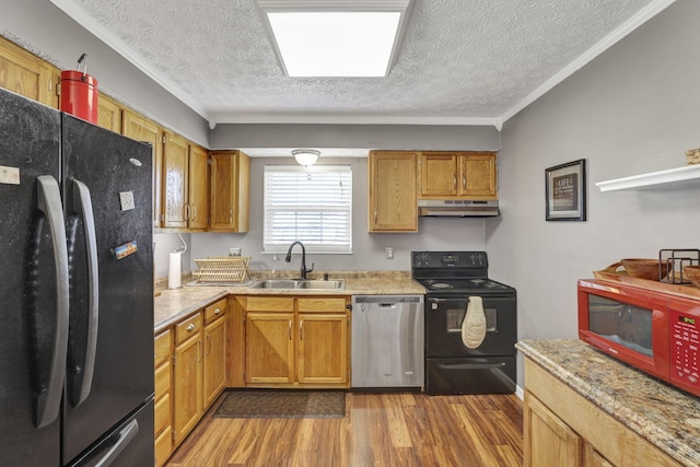 kitchen featuring a textured ceiling, a sink, black appliances, dark wood-style floors, and under cabinet range hood