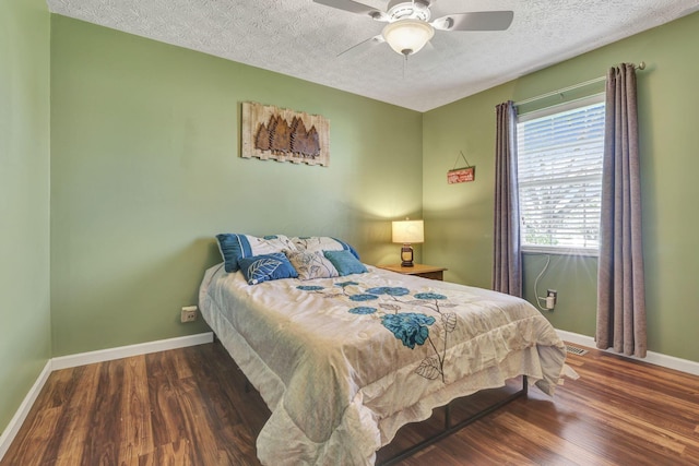 bedroom featuring baseboards, a textured ceiling, ceiling fan, and wood finished floors