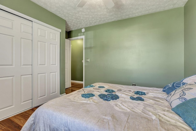 bedroom with a ceiling fan, a closet, dark wood finished floors, and a textured ceiling