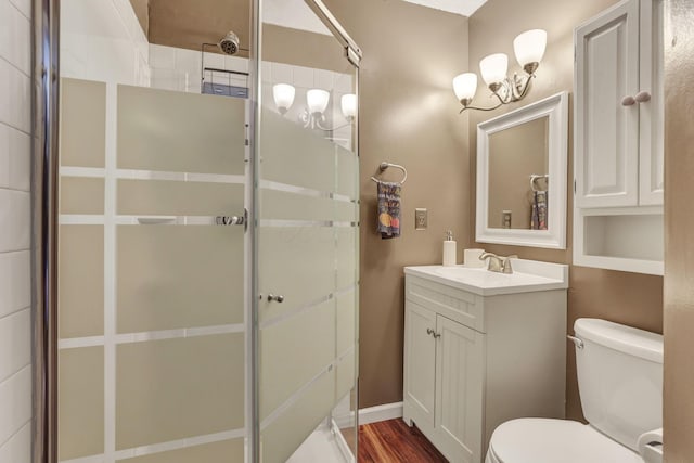 full bathroom featuring vanity, a shower stall, toilet, and a chandelier