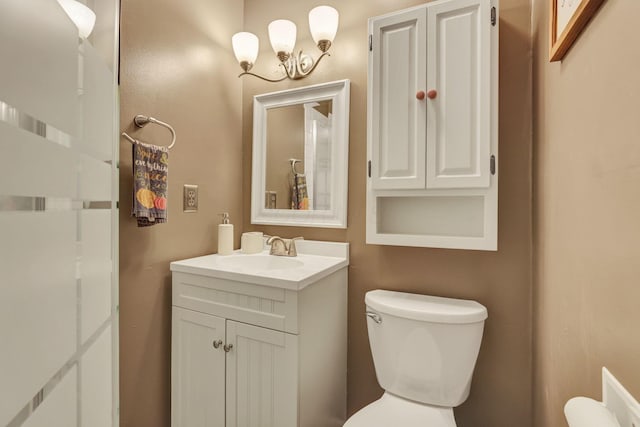 bathroom with vanity, toilet, and a chandelier