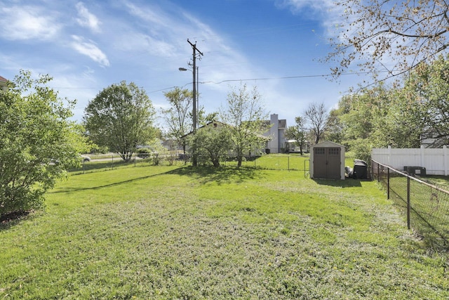 view of yard with a storage shed, an outdoor structure, and a fenced backyard