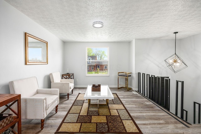 5930 Parkglen Rd, Galloway, OH 43119 - sitting room featuring wood finished floors, a textured ceiling, baseboards, and a notable chandelier