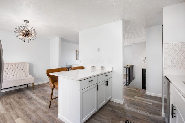 5930 Parkglen Rd, Galloway, OH 43119 - kitchen with light countertops, a textured ceiling, a kitchen breakfast bar, and dark wood-style flooring