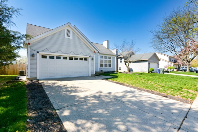 view of front of property with a chimney, a front lawn, concrete driveway, fence, and a garage