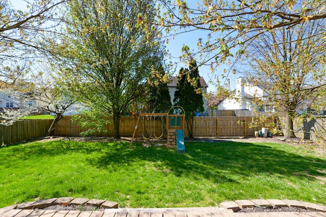 view of yard with a fenced backyard and a playground