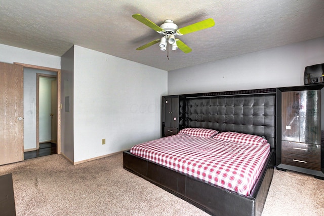 bedroom featuring baseboards, carpet floors, a textured ceiling, and ceiling fan