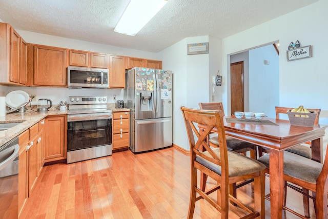 730 Erin St, Lewis Center, OH 43035 - kitchen featuring a textured ceiling, appliances with stainless steel finishes, light stone counters, and light wood-style floors