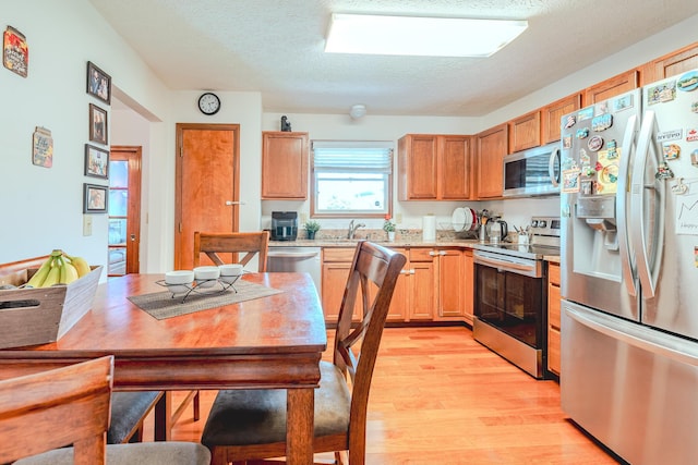 730 Erin St, Lewis Center, OH 43035 - kitchen featuring a textured ceiling, appliances with stainless steel finishes, a sink, light countertops, and light wood-style flooring