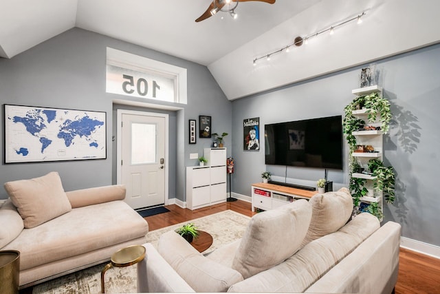 living room with ceiling fan, track lighting, baseboards, wood finished floors, and vaulted ceiling