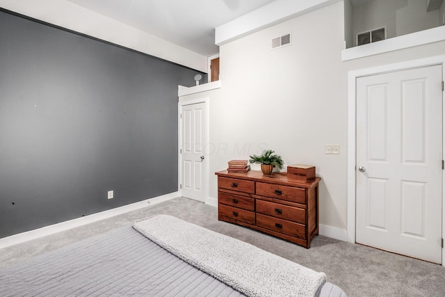 carpeted bedroom featuring visible vents and baseboards