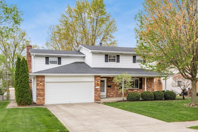 traditional home featuring a front lawn, a chimney, driveway, brick siding, and an attached garage