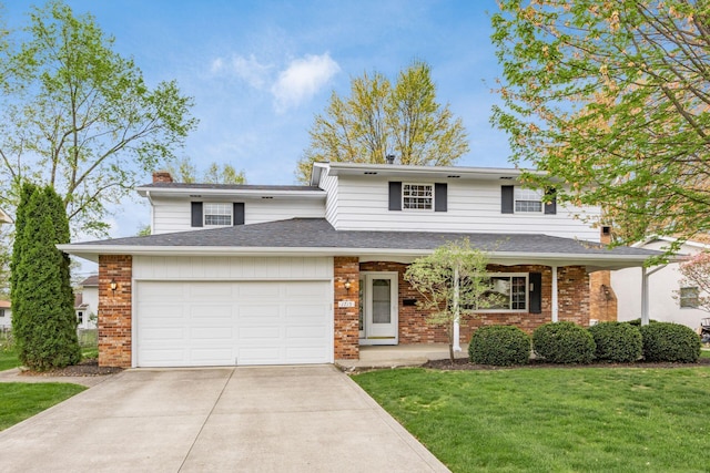 traditional-style home with concrete driveway, a chimney, a front yard, an attached garage, and brick siding