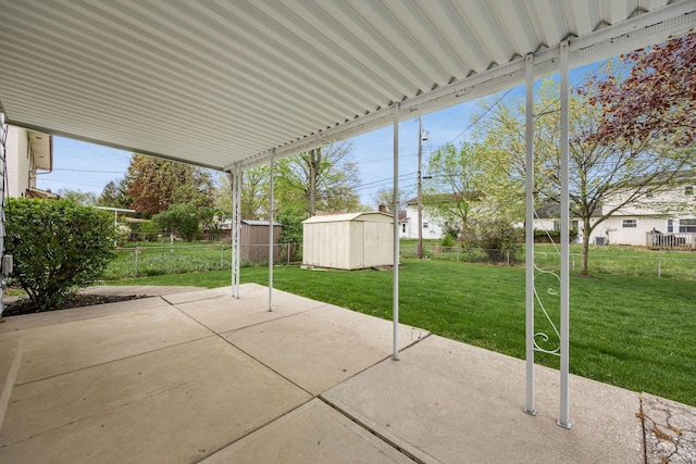 view of patio / terrace with a storage unit, a fenced backyard, and an outbuilding