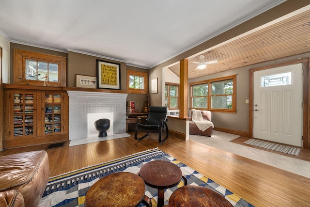 1397 Glenn Ave, Columbus, OH 43212 - living room featuring a brick fireplace, wood finished floors, ornamental molding, healthy amount of natural light, and baseboards
