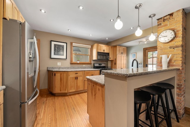 1397 Glenn Ave, Columbus, OH 43212 - kitchen with appliances with stainless steel finishes, a breakfast bar, light wood finished floors, light stone counters, and recessed lighting