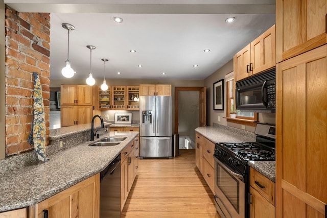 1397 Glenn Ave, Columbus, OH 43212 - kitchen with black appliances, a sink, light wood-style flooring, dark stone counters, and hanging light fixtures