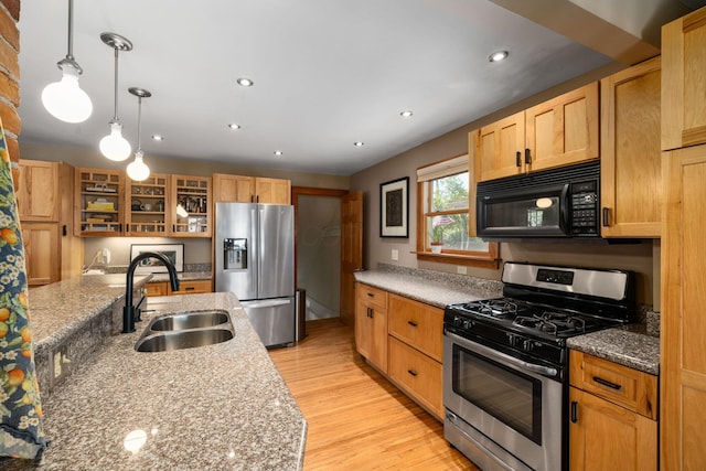 1397 Glenn Ave, Columbus, OH 43212 - kitchen featuring appliances with stainless steel finishes, a sink, light wood-type flooring, glass insert cabinets, and light stone countertops