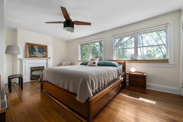 1397 Glenn Ave, Columbus, OH 43212 - bedroom featuring baseboards, wood-type flooring, ceiling fan, crown molding, and a brick fireplace